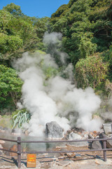 Fototapeta na wymiar Hot Spring water boiling from stone ground, Beppu, Oita, Japan, Japanese language in placard paper means 