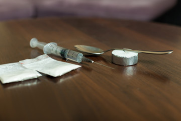 Drug, spoon and syringe on a table