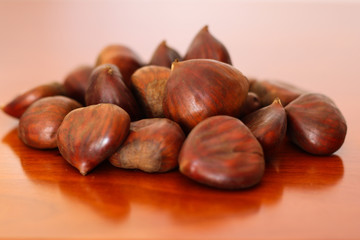 Raw chestnuts on wooden background
