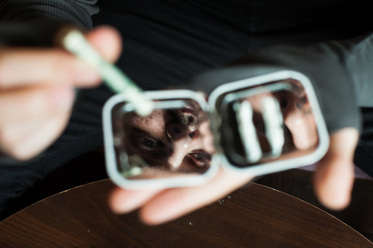 Addict Smells Cocaine From A Mirror Closeup.