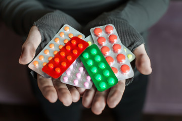 Male hands is holding a lot of different tablets.
