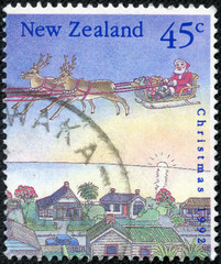 stamp printed in New Zealand dedicated to christmas shows santa with sleigh on the city