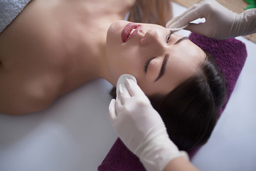 Masseur doing massage the head of an adult woman in the spa salon