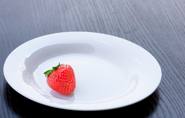 ripe strawberries on a white plate, background