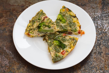 Spanish tortilla on a white plate. Restaurant supply. Old table. Top view. Close-up