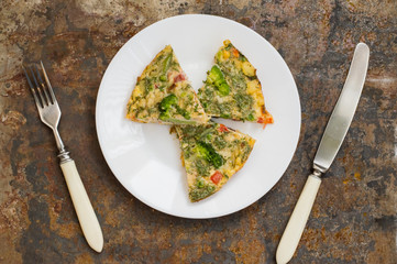 Spanish tortilla on a white plate. Restaurant supply. Old table. Top view. Close-up