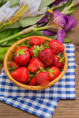 Strawberries in the basket on wooden background