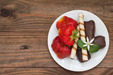 Strawberries with chocolate. Wooden table. Top view. Close-up