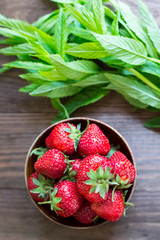 Strawberries in the plate on wooden background. Top view. Close-up