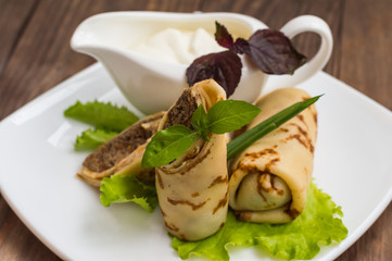 Pancakes with a liver on  wooden table. Restaurant supply. Top view. Close-up