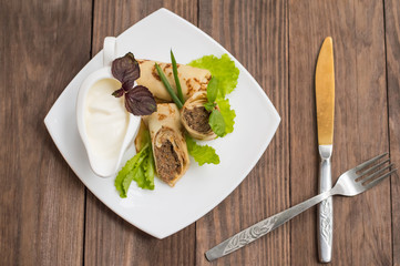 Pancakes with a liver on  wooden table. Restaurant supply. Top view. Close-up