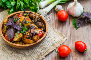 Roasted meat with potatoes, ojaxuri, hot in Georgian and red wine on a wooden table. Top view. Close-up