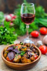 Roasted meat with potatoes, ojaxuri, hot in Georgian and red wine on a wooden table. Top view. Close-up