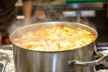The soup is cooked in a large pot in the kitchen in the restaura