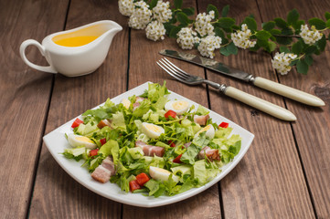Salad with spinach, quail eggs and bacon. Wooden table. Top view. Close-up