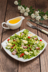 Salad with spinach, quail eggs and bacon. Wooden table. Top view. Close-up