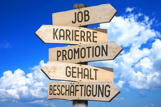 Wooden signpost - job concept - "Job", "Karierre", "Promotion", "Gehalt", "Beschaftigung" (German)/ "Job", "Career", "Promotion", "Salary", "Occupation" (English).