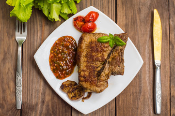 Rare Beef steak medium grilled with barbecue sauce. Wooden table. Top view