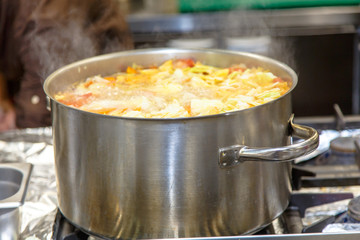 The soup is cooked in a large pot in the kitchen in the restaura
