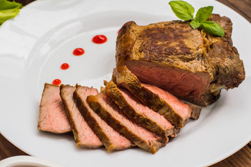 Rare Beef steak medium grilled with barbecue sauce. Wooden table. Top view. Close-up