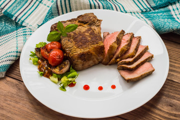 Rare Beef steak medium grilled with barbecue sauce. Wooden table. Top view. Close-up