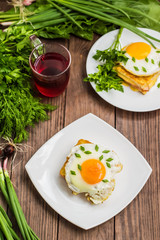 Croque-Madame, a French sandwich with greens and berry juice for breakfast. Wooden table. Top view. Close-up