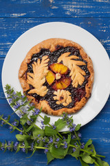 Cake with currant jam and slice of orange on a wooden background. Homemade baking. Top view. Close-up