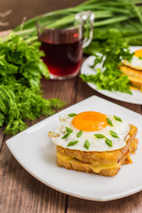 Croque-Madame, a French sandwich with greens and berry juice for breakfast. Wooden table. Top view. Close-up