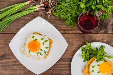 Croque-Madame, a French sandwich with greens and berry juice for breakfast. Wooden table. Top view. Close-up