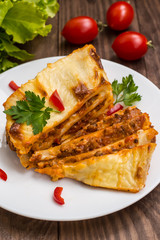 Lasagna, traditional Italian food on a wooden background