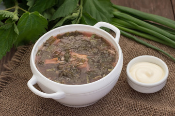 Borsch from a nettle on  wooden table. Top view