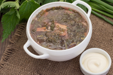 Borsch from a nettle on  wooden table. Top view
