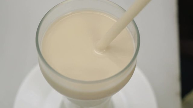 Close-up shot of woman drinking horchata with a straw. Refreshing beverage made of nutsedge