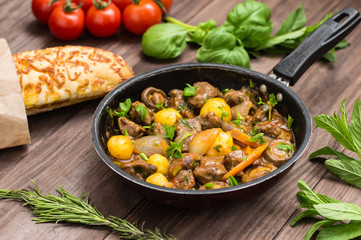 Meat in Burgundy in a frying pan. Old background. Top view