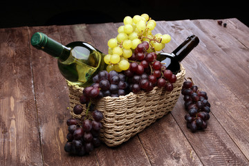 Obraz premium Bottle of white wine, grape and corks on wooden table 