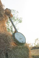 .Banjo resting on straw Division in the fields, the warm sun of