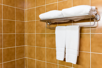 folded white towels hanging on metal rack