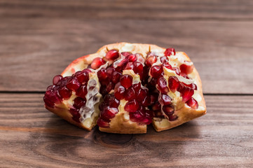 Pomegranate, ripe and cut on a wooden background