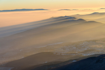 Beautiful frosty sunrise in the mountains - Vitosha, Bulgaria - mountain tops peaking out through...