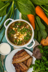 Green soup with eggs and ingredients for his cooking. Old background