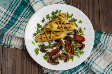 Zrazy Potato stuffed with meat  mushrooms and grilled tomatoes on a white plate. Wooden background. Top view. Close-up