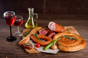 The breast meat sausage on wooden Board with vegetables and red wine