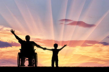 Obraz na płótnie Canvas Disabled in wheelchair with her son happy on sunset background