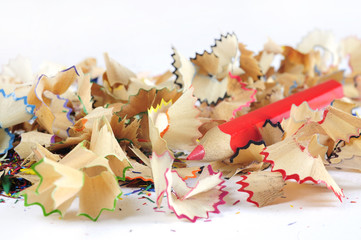 Wooden colorful pencils with sharpening shavings, on wooden table
