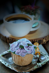 Blue cupcake design cream like blue Hydrangea flower Served with hot black coffee on wooden table background and have some space for write wording