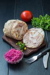 Aspic with meat and horseradish on a wooden table