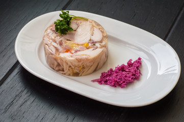 Aspic with meat and horseradish on a wooden table