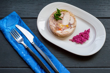 Aspic with meat and horseradish on a wooden table