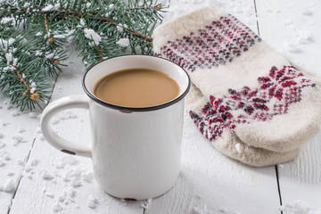 Hot chocolate in a mug and warm knitted mittens