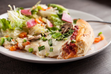 Home made pizza from scratch topped with mushrooms, turkey, kale, peppers, and tomatoes macro shot